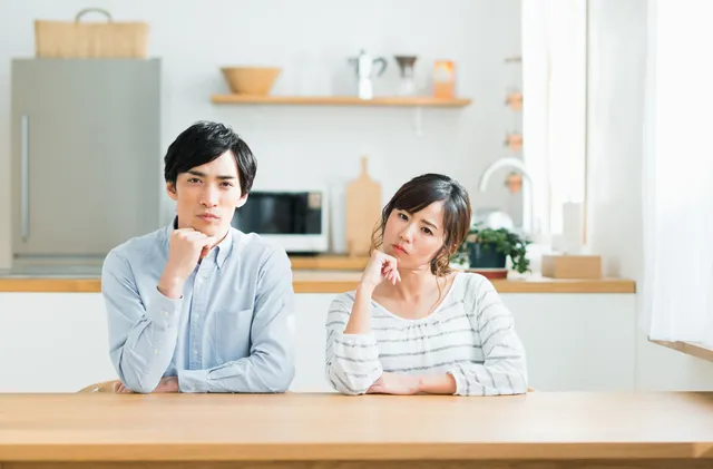 互いに首を傾げるカップル