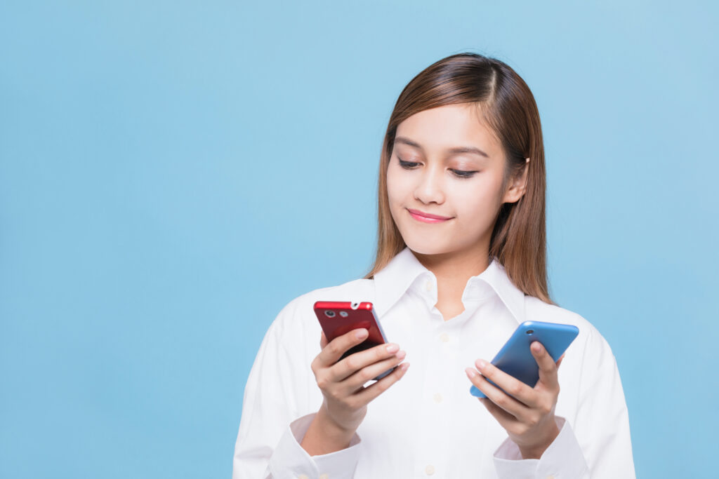 スマホを見比べる女性