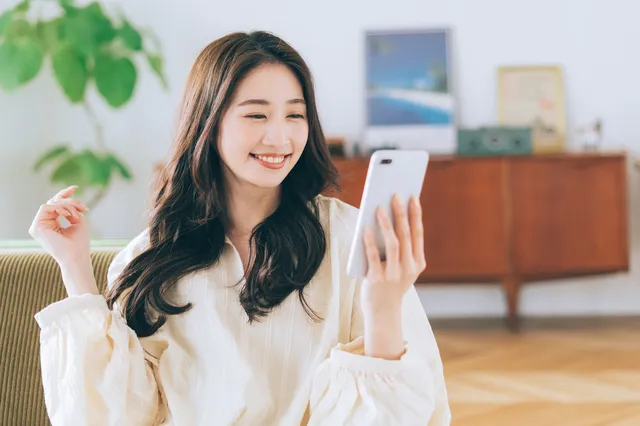 スマホを笑顔で眺める女性
