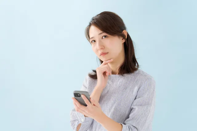 スマホを持って考える女性