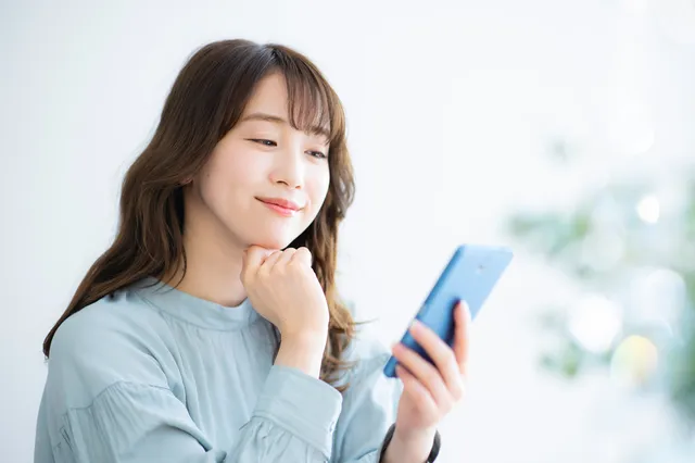 スマホを持って考える女性