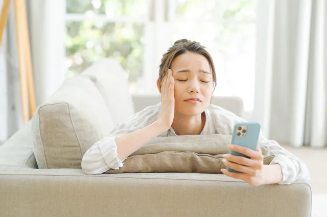スマホを持って考える女性