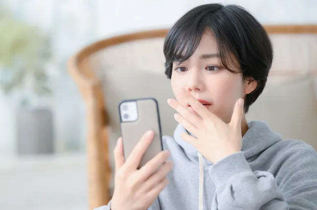 スマホを持って考える女性