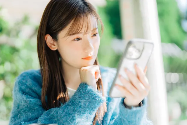 スマホを見て考える女性
