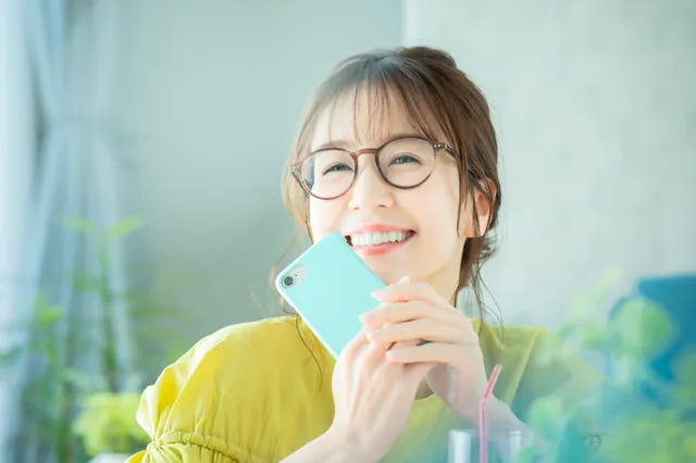 笑顔でスマホを持つ女性
