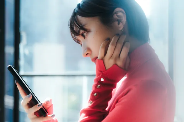 スマホを見て悩む女性