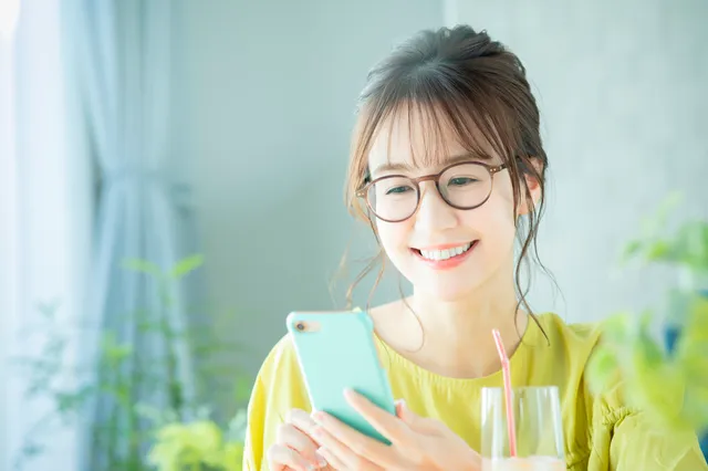 笑顔でマッチングアプリを利用する女性