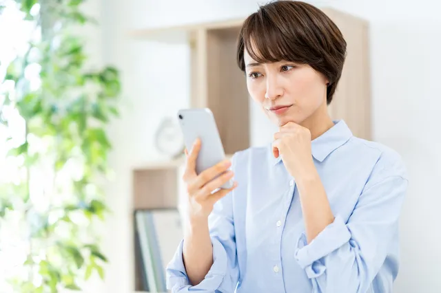 スマホを見て困る女性